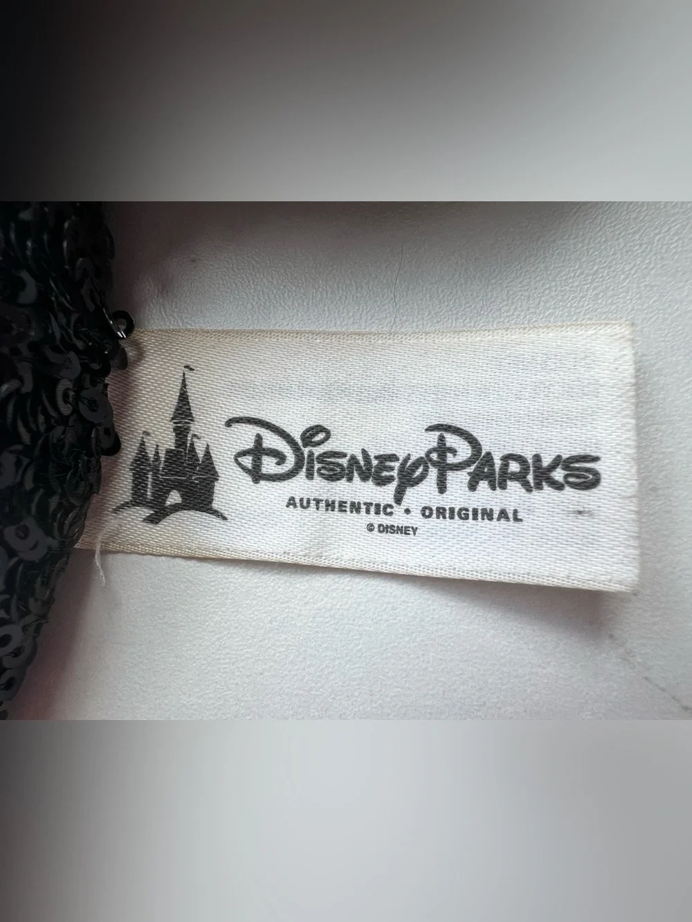 Disney Parks Authentic White Label, black sequin ears with a read sequin bow.